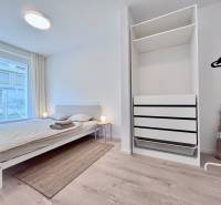 NUERA︱NOVÝ RUŽINOV - kompletne zariadený 2-izbový apartmán so záhradou - Svetlá spálňa s podlahou s dreveným dekorom, manželskou posteľou a priestrannou skriňou v 2-izbovom byte.