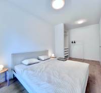 NUERA︱NOVÝ RUŽINOV - kompletne zariadený 2-izbový apartmán so záhradou - Svetlá spálňa s posteľou, nočný stolík, vešiak, podlaha s dreveným dekorom, 2-izbový byt.