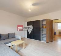 Rodinný dom Slovenský Grob, podpivničený, podkrovie, záhrada - Obývacia izba v rodinnom dome s pohovkou, skriňou a stolíkom, podlaha s dreveným dekorom.