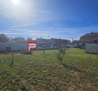 Pekný pozemok 830 m2 v Slovenskom Grobe so starším domom - Záhrada pri rodinnom dome na Chorvátskej ulici v Slovenskom Grobe s plotom a trávnikom.