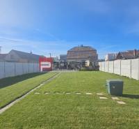 Pekný pozemok 830 m2 v Slovenskom Grobe so starším domom - Záhrada pri rodinnom dome na Chorvátskej ulici v Slovenskom Grobe s trávnikom a chodníkom.