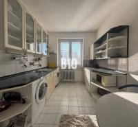 Sad na Studničkách - 2 izbový byt 60m2 - Kuchyňa v 2-izbovom byte s bielymi skrinkami a čiernou pracovnou doskou.