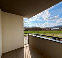 Na predaj 2-izbový byt v novostavbe s parkingom, Na pažiti, Trenčín - Balkón v 2-izbovom byte na ulici Na pažiti v Trenčíne s výhľadom na zeleň a cestu.