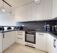 Na predaj 2-izbový byt v novostavbe s parkingom, Na pažiti, Trenčín - Kuchyňa v 2-izbovom byte s čiernou pracovnou doskou a bielymi skrinkami.