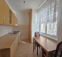 Predaj - 3 izbový byt,  69 m2, balkón,  ul.ČSA, KE - Staré Mesto - Kuchyňa s drevenými skrinkami, stolom a dvomi stoličkami v 3-izbovom byte.