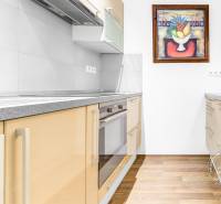 2-izb. byt v RD, TERASA, BA IV Dúbravka, Tavarikova Osada - Kuchyňa v 2-izbovom byte s varešou, drevenou podlahou a umeleckým obrazom.