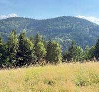 Chata pred dokončením, pozemok 770 m2, Horná Maríková - Horská krajina pri Hornej Marikovej s lesmi a lúkou pod slnečnou oblohou.