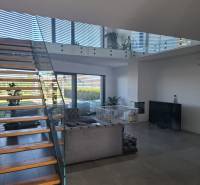 Moderný rodinný dom so záhradou, bazénom a nadštandardným priestorom - Obývacia izba v rodinnom dome so schodiskom a presklenými zábradliami.