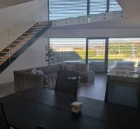 Moderný rodinný dom so záhradou, bazénom a nadštandardným priestorom - Jedálenský stôl a schodisko v rodinnom dome s výhľadom do záhrady.