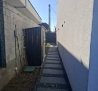 Moderný rodinný dom so záhradou, bazénom a nadštandardným priestorom - Úzka bočná cestička so štrkom v Rodinnom dome v Zvončíne.