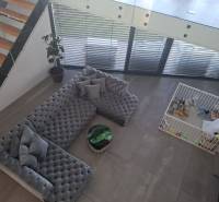 Moderný rodinný dom so záhradou, bazénom a nadštandardným priestorom - Obývačka v rodinnom dome s veľkou sedačkou, detským kútikom a schodmi.