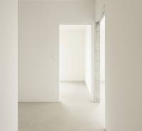 4-izbový rodinný dom Galanta – HODY - bez rezervačnej zálohy - Prázdny interiér rodinného domu s bielymi stenami a betónovou podlahou.