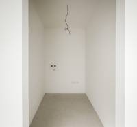 4-izbový rodinný dom Galanta – HODY - bez rezervačnej zálohy - Prázdna miestnosť v rodinnom dome s bielymi stenami a betónovou podlahou.