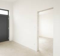 4-izbový rodinný dom Galanta – HODY - bez rezervačnej zálohy - Pohľad do interiéru rodinného domu s bielymi stenami a tmavými dverami.