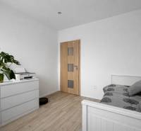 NOVINKA - Priestranných 74 m² v štýlovo zariadenom byte - Svetlá spálňa v 3-izbovom byte s bielym nábytkom a podlahou s dreveným dekorom.