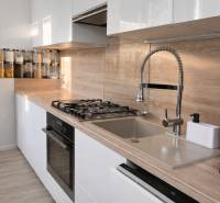 NOVINKA - Priestranných 74 m² v štýlovo zariadenom byte - Kuchyňa v 3-izbovom byte s podlahou s dreveným dekorom a praktickým usporiadaním.