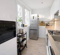 NOVINKA - Priestranných 74 m² v štýlovo zariadenom byte - Kuchyňa v 3-izbovom byte s podlahou s dreveným dekorom a modernými spotrebičmi.