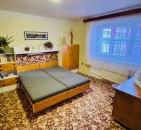 Na predaj 3 i  byt s loggiou aj terasou - Prievidza 75,24 m2 - Izba v 3-izbovom byte s dreveným dekorom nábytku a kobercom na podlahe.