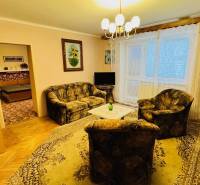 Na predaj 3 i  byt s loggiou aj terasou - Prievidza 75,24 m2 - Obývacia izba v 3-izbovom byte s pohovkou, kreslom a podlahou s dreveným dekorom.