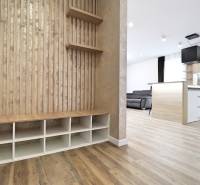 Na PRENÁJOM_v NOVOSTAVBE krásny 3-izbový byt s parkovacím státím - Interiér 3-izbového bytu s podlahou s dreveným dekorom, kuchyňou a obývacou časťou.