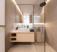 LUXUSNÝ 3-IZBOVÝ BYT NA MIERU V NADČASOVEJ NOVOSTAVBE NA ZAČIATKU KOLI - Kúpeľňa so zrkadlom, sprchou a dreveným dekorom v 3-izbovom byte.