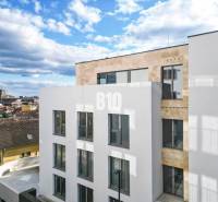 LUXUSNÝ 3-IZBOVÝ BYT NA MIERU V NADČASOVEJ NOVOSTAVBE NA ZAČIATKU KOLI - Biela budova s veľkými oknami v Bratislave III na Matúškovej so 3-izbovým bytom.