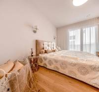 LUXUSNÝ 3-IZBOVÝ BYT NA MIERU V NADČASOVEJ NOVOSTAVBE NA ZAČIATKU KOLI - Spálňa v 3-izbovom byte s posteľou a podlahou s dreveným dekorom.