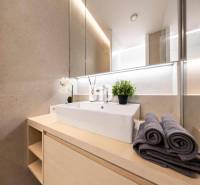 LUXUSNÝ 3-IZBOVÝ BYT NA MIERU V NADČASOVEJ NOVOSTAVBE NA ZAČIATKU KOLI - Kúpeľňa s moderným umývadlom, uterákmi a dekoráciou v 3-izbovom byte.