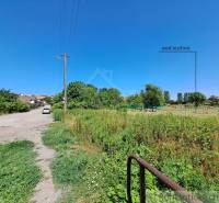 Stavebný pozemok pri Nitre so stavebným povolením v tichej lokalite - Cesta vedie k Pozemkom - bývanie v Hosťovej s výhľadom na zeleň a domy.