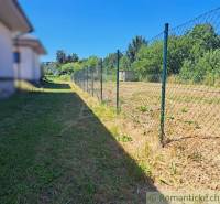 Stavebný pozemok pri Nitre so stavebným povolením v tichej lokalite - Trávnatý pozemok s plotom v Hosťovej, ideálny na bývanie.