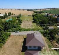 Stavebný pozemok pri Nitre so stavebným povolením v tichej lokalite - Hosťová zobrazuje vidiecke pozemky na bývanie s panorámou mosta v pozadí.