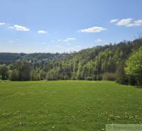 Vaša vlastná oáza na lazoch: Pozemok s dušou a krásnym výhľadom - Jarná krajina v okolí Krupiny, Pozemky - bývanie, zelené lúky a lesy na horizonte.