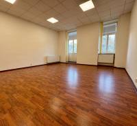 Priestor na prenájom - 35 m2 - Moyzesova, Košice - Prázdna kancelária s podlahou s dreveným dekorom a veľkými oknami.