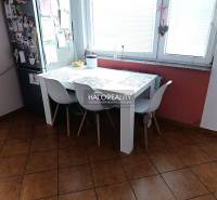Prenájom, dvojizbový byt Nováky - Kuchyňa 2-izbového bytu s jedálenským stolom, bielymi stoličkami a oknom.
