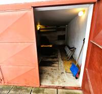 Predaj 5-izbový dom v Kameňanoch, okres Revúca - Garáž v rodinnom dome v Kameňanoch s otvorenými kovovými dverami a náradím.