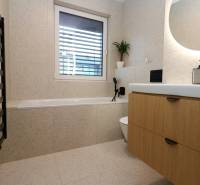 NUERA︱Penthouse s terasou s krásnymi výhľadmi v Dúbravke - Kúpeľňa v 4-izbovom byte s vaňou, umývadlom a dreveným dekorom skrinky.