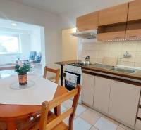 Na PRENÁJOM, VEĽKÝ 2 izb. TEHLOVÝ BYT, SÍDLISKO II., PREŠOV  - Kuchyňa v 2-izbovom byte s posedením, svetlou podlahou a jedálenským stolom.