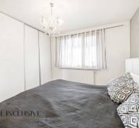 Na predaj 4-izb. byt s loggiou , Dunajská Streda - Spálňa v 4-izbovom byte s lusterom, šatníkovou skriňou a tmavým posteľným oblečením.