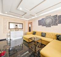 Na predaj 4-izb. byt s loggiou , Dunajská Streda - Obývacia izba s veľkými žltými pohovkami v 4-izbovom byte, s čiernou podlahou.