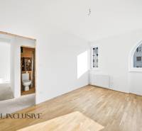 Na predaj zrekonštr. 3-izb. byt s balkónom, Dun.Streda - Prázdna miestnosť s radiátorom a podlahou s dreveným dekorom v 3-izbovom byte.