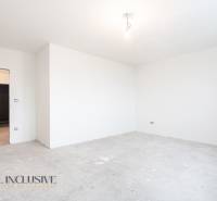 Na predaj poschodový 6-izbový rodinný dom, Horné Mýto - Prázdna miestnosť v rodinnom dome, biele steny, nedokončená podlaha bez dreveného dekoru.