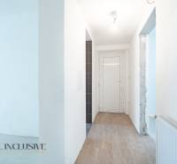 Na predaj poschodový 6-izbový rodinný dom, Horné Mýto - Chodba v rodinnom dome s podlahou s dreveným dekorom a bielou stenou.