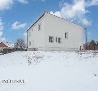 Na predaj poschodový 6-izbový rodinný dom, Horné Mýto - Rodinný dom v Hornom Mýte zasnežený počas zimy s modrou oblohou.