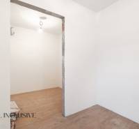 Na predaj poschodový 6-izbový rodinný dom, Horné Mýto - Miestnosť v rodinnom dome s bielymi stenami a podlahou s dreveným dekorom.