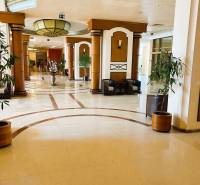 Štúdio DIT Majestic Beach Resort v 1. línií pri mori Bulharsko  - Elegantná hotelová chodba s dekoratívnymi stĺpmi a rastlinami v kvetináčoch.