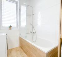 Na predaj 3 izbový byt s terasou, Trenčín, ul. Saratovská - Kúpeľňa v 3-izbovom byte s vaňou a podlahou s dreveným dekorom.