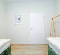 Na predaj 3 izbový byt s terasou, Trenčín, ul. Saratovská - Svetlá spálňa v 3-izbovom byte s podlahou s dreveným dekorom a minimalistickou výzdobou.