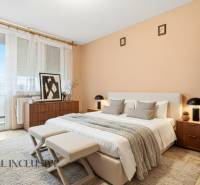 Na predaj 4-izb. rodinný dom s garážou, Okoč - Spálňa v rodinnom dome s posteľou, dekoráciami a rastlinou, svetlé steny a okno.