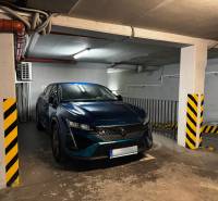 Na predaj veľký 2-izbový byt s terasou a wellness - Koliba - Zaparkované auto v podzemnej garáži s bezpečnostnými pruhmi a osvetlením.