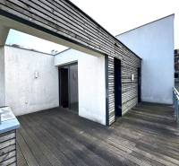 Na predaj veľký 2-izbový byt s terasou a wellness - Koliba - Balkónový priestor s drevenou podlahou a modernou architektúrou pri 2-izbovom byte.